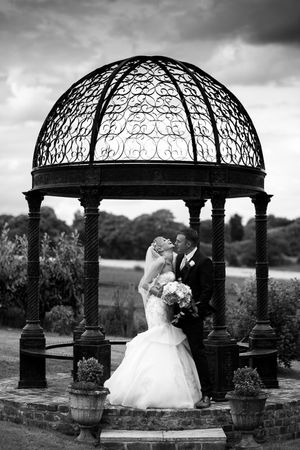 Black and white photo of Bride laughing under gazebo