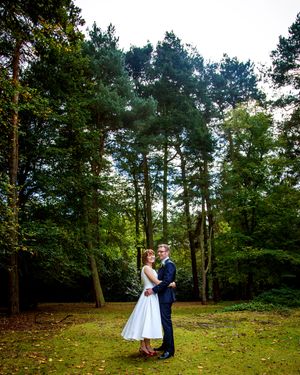 bride and groom hugging in wooded area